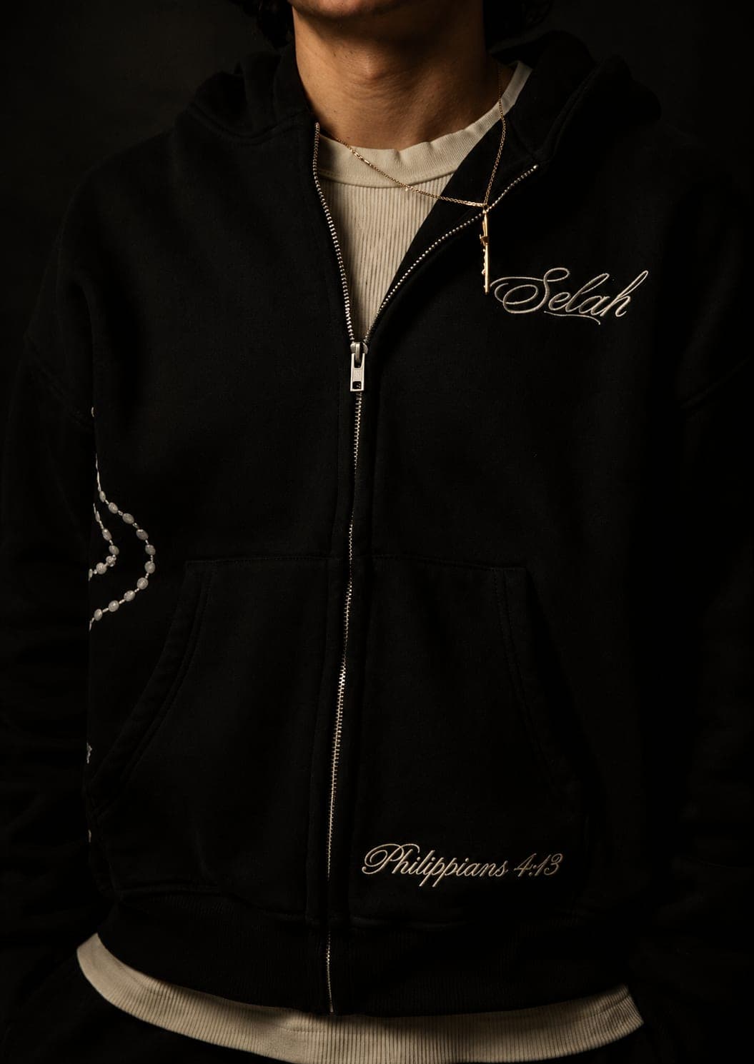 Rosary Zip Hoodie in matte black, worn with the rosary print and Philippians 4:13 embroidery visible