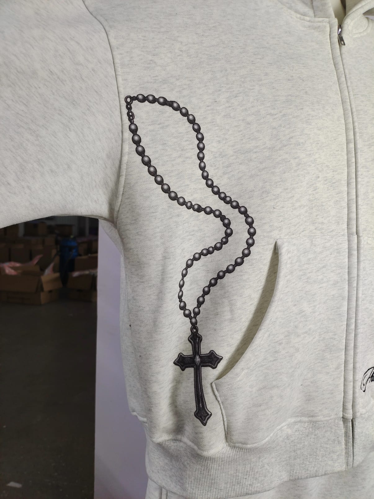 Rosary print over the pocket of the washed bone hoodie